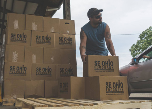 Man carrying foodbank boxes at warehouse