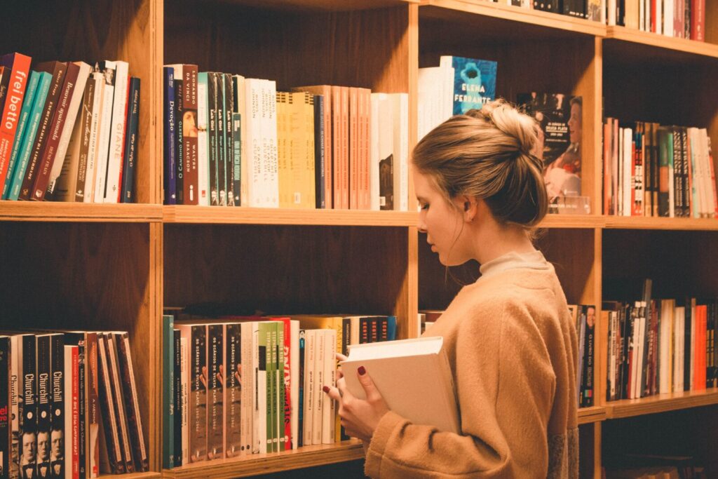 Woman looking for books in library. College